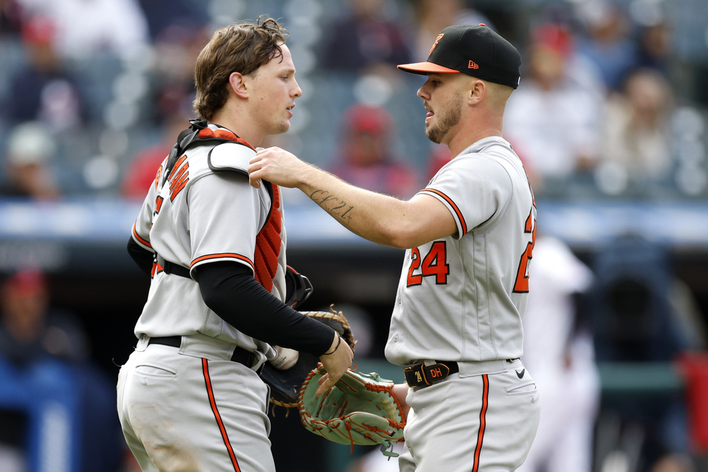 Baltimore Orioles relief pitcher DL Hall (24) and catcher Adley Rutschman, left, celebrate...